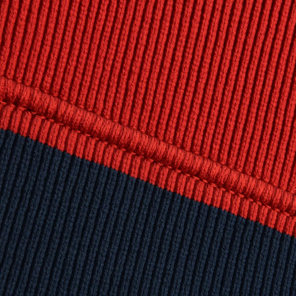 Macro detail of ribbed navy and red wrestling singlet fabric with a stitched seam